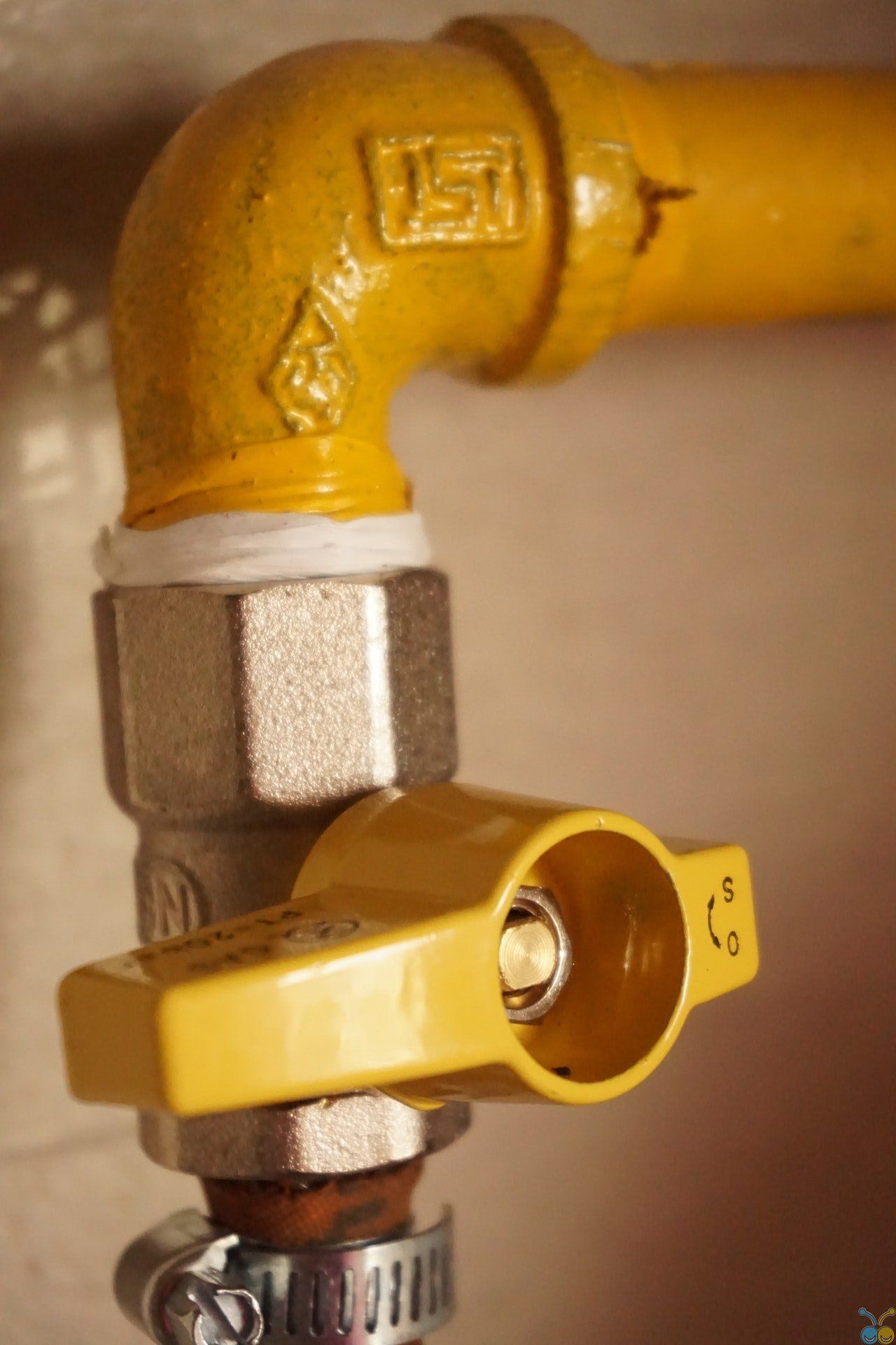 A yellow gas valve is attached to a yellow pipe